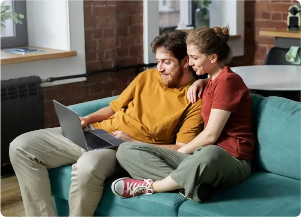 Couple relaxing on a sofa with a laptop